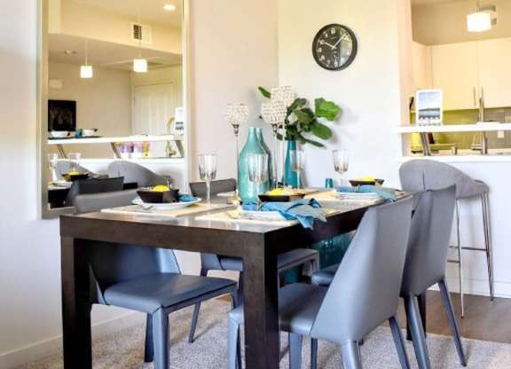 Dining room with modern chairs and large mirror at 360 Luxury Apartments, San Diego, 92122