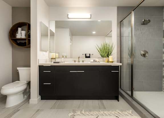 Modern bathroom with glass shower and vanity at LUX by Garden* Apartments, San Diego, CA 92122