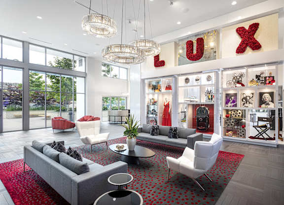 Elegant lobby with designer chandeliers and showcase wall at LUX by Garden* Apartments, California