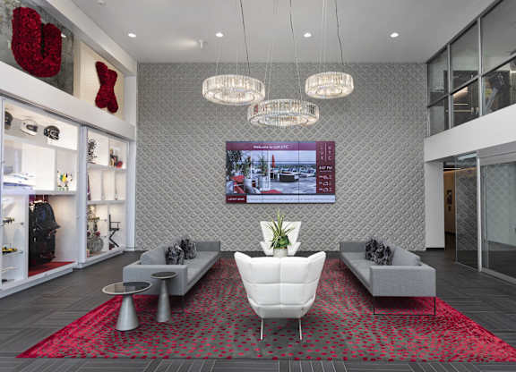 Lobby seating area with crystal chandeliers and display shelving at LUX by Garden* Apartments, California, 92122
