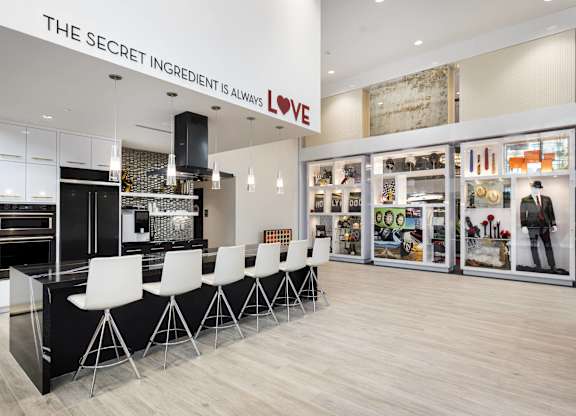 Community kitchen with island seating and wall display at LUX by Garden* Apartments, San Diego, CA 92122