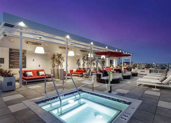 Rooftop hot tub with lounge furniture at dusk at LUX by Garden* Apartments, San Diego, 92122