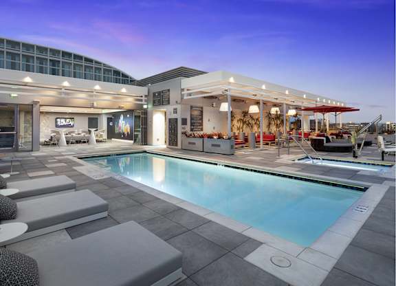 Rooftop pool area with cabanas at twilight at LUX by Garden* Apartments, San Diego, California