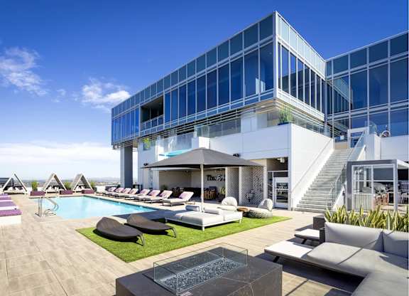 Rooftop amenity deck with pool and grassy lounge at LUX by Garden* Apartments, San Diego