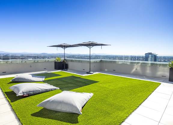 Rooftop terrace with artificial turf and cushioned seating at LUX by Garden* Apartments, San Diego, CA 92122