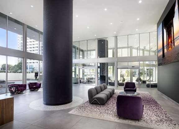 Modern lobby with curved seating and column at LUX by Garden* Apartments, San Diego, CA