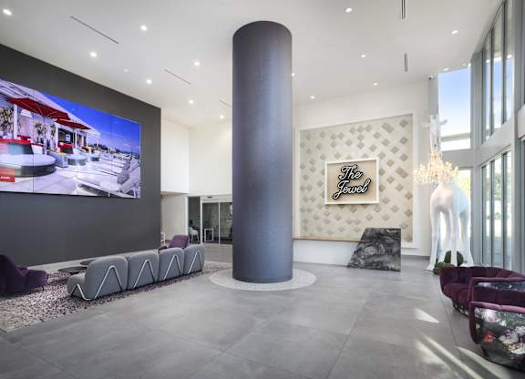 Modern lobby with video wall and sculptural seating at LUX by Garden* Apartments, San Diego, 92122