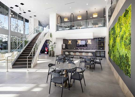 Resident dining area with living wall and staircase at LUX by Garden* Apartments, San Diego, California
