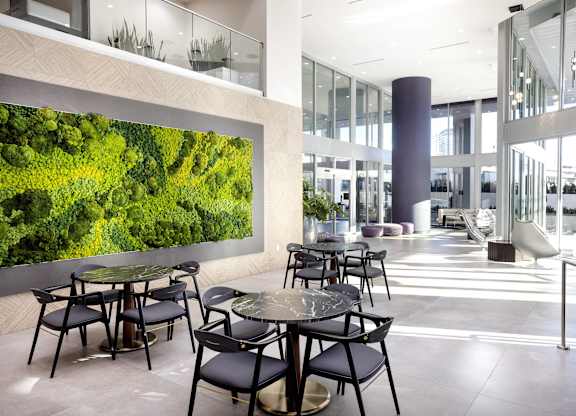 Modern lobby with moss wall and dining tables at LUX by Garden* Apartments, San Diego