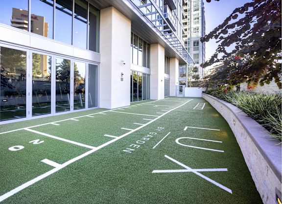 Outdoor shuffleboard court on synthetic turf with planters at LUX by Garden* Apartments, San Diego, CA 92122