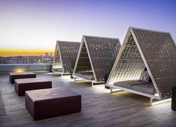 Rooftop cabanas with woven walls and ambient lighting at LUX by Garden* Apartments, California, 92122