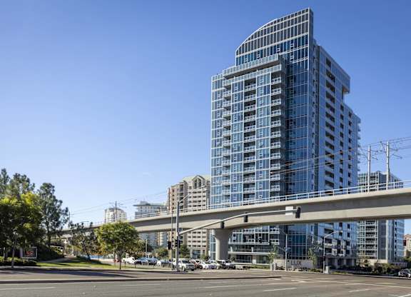 Modern high rise building with elevated transit line at LUX by Garden* Apartments, San Diego, CA