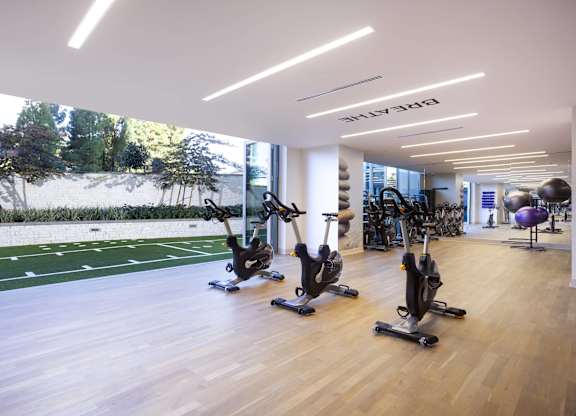 Fitness center with stationary bikes and turf training area at LUX by Garden* Apartments, San Diego, CA