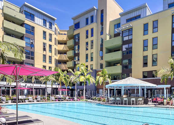 Lap pool with loungers and poolside dining pavilion at Metropolis Apartments, IRVINE, 92614