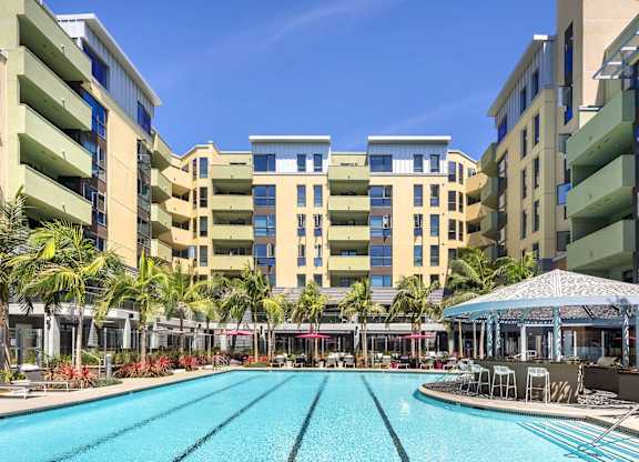 Lap pool with courtyard seating and dining pavilion at Metropolis Apartments, IRVINE