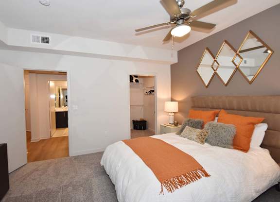Bedroom with ceiling fan and walk-in closet at Metropolis Apartments, IRVINE, CA