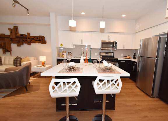 A modern kitchen with a white table and chairs.at Metropolis Apartments, IRVINE, 92614