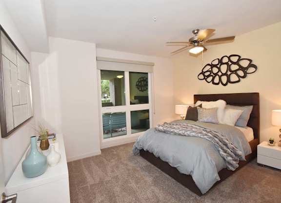 A Bedroom with a large bed and a ceiling fan.at Metropolis Apartments, California, 92614