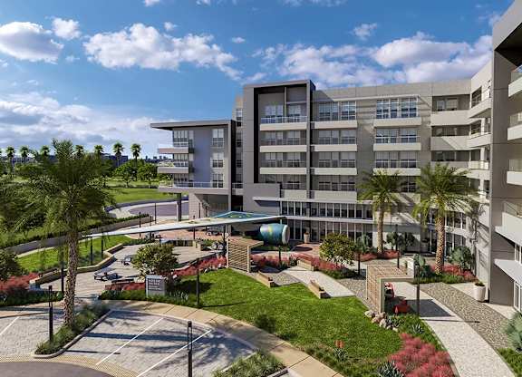 A modern building with a parking lot in front.at Volar Apartments, Irvine, CA 92612