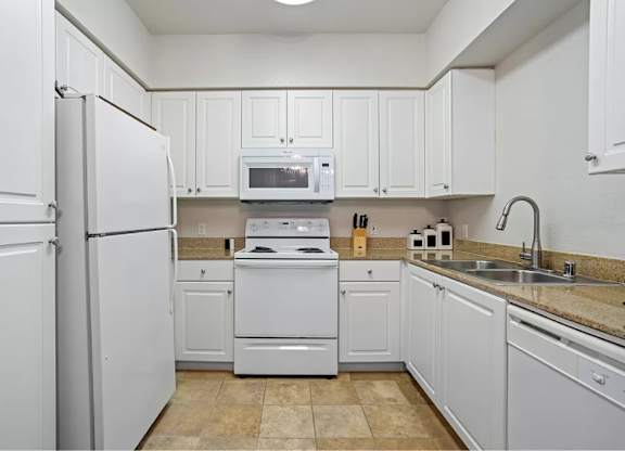 A kitchen with white appliances and cabinets. at Towers at Costa Verde Apartments, San Diego, CA