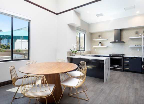 A modern kitchen with a round wooden table and chairs. at Towers at Costa Verde Apartments, San Diego, CA