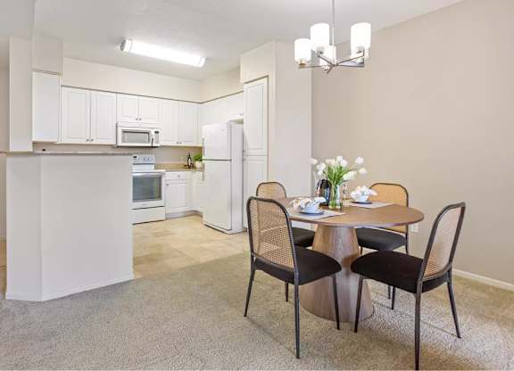 A kitchen with a dining table and chairs. at Towers at Costa Verde Apartments, San Diego, CA