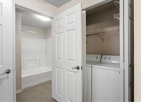 A white bathroom with a washer and dryer in the doorway. at Towers at Costa Verde Apartments, San Diego, CA, 92122