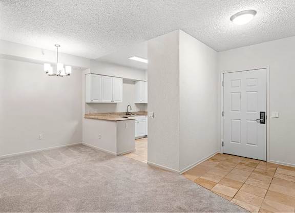 A spacious room with a kitchenette and a door. at Towers at Costa Verde Apartments, San Diego, CA