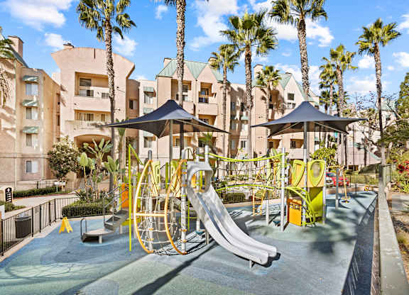 Children playground with shade canopies and apartment buildings at Costa Verde Village Apartments, San Diego, California