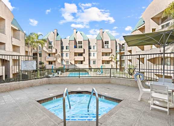 Hot tub area with pool and apartment buildings at Costa Verde Village Apartments, San Diego