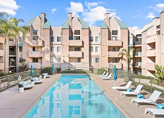 Pool courtyard with lounge chairs and landscaping at Costa Verde Village Apartments, California
