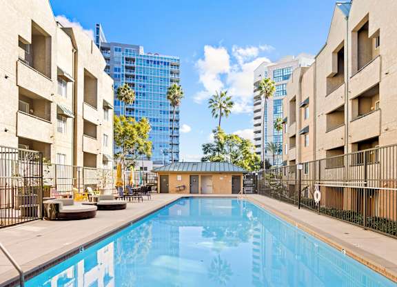 Pool deck with courtyard seating and palm trees at Costa Verde Village Apartments, San Diego, 92122