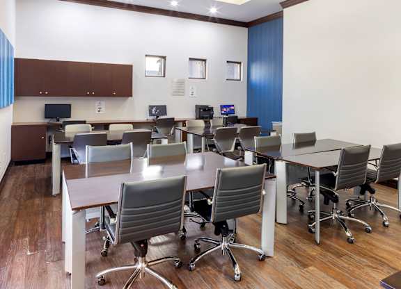 Business center with computer desks and office chairs at Costa Verde Village Apartments, California