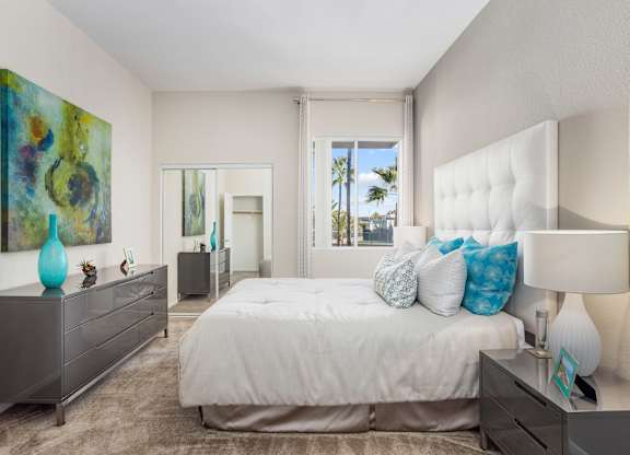 Modern bedroom with tufted headboard and palm tree views at Costa Verde Village Apartments, San Diego, CA 92122