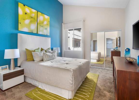 Bedroom with blue accent wall and mirrored closet doors at Costa Verde Village Apartments, San Diego, 92122