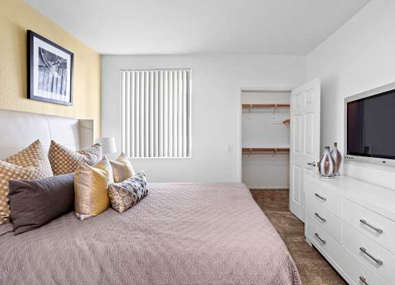 Bedroom with white dresser and walk-in closet at Costa Verde Village Apartments, San Diego