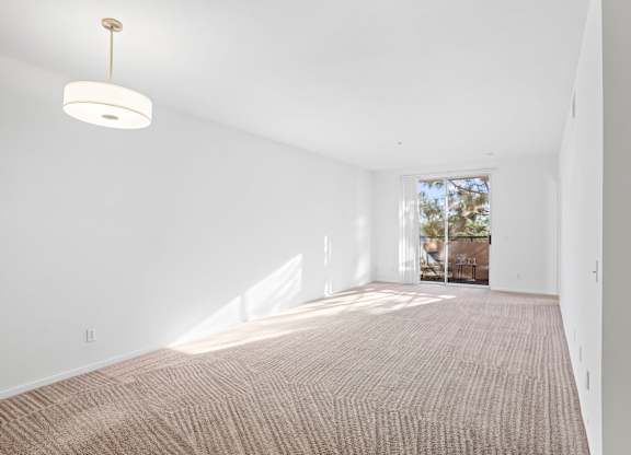 Empty carpeted room with pendant light and balcony at Costa Verde Village Apartments, California, 92122