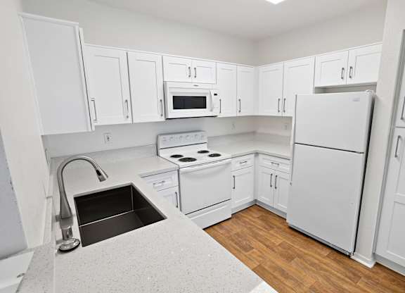 Bright kitchen with white cabinetry and modern appliances at Costa Verde Village Apartments, San Diego, CA