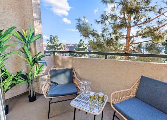 Balcony seating area with tree views at Costa Verde Village Apartments, San Diego