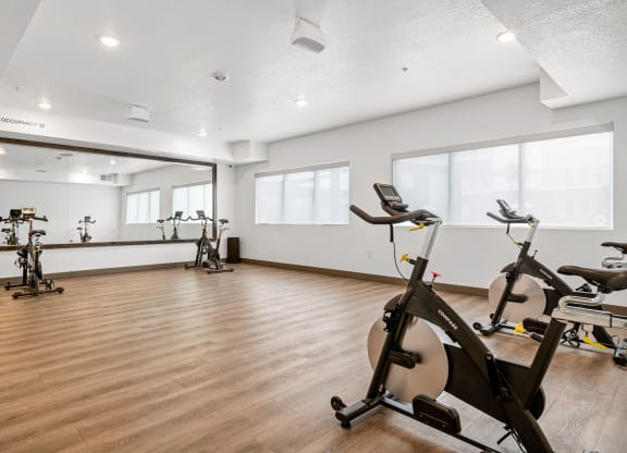 a gym with white walls and hardwood flooring