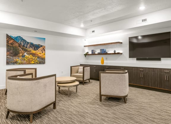 a resident clubhouse with a large tv and chairs