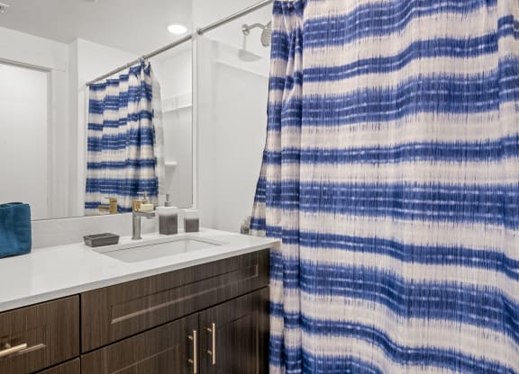 a bathroom with a sink and shower in a 555 waverly unit