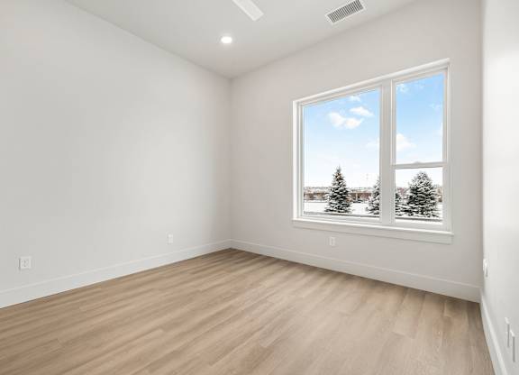 A room with a large window showing a snowy landscape outside.