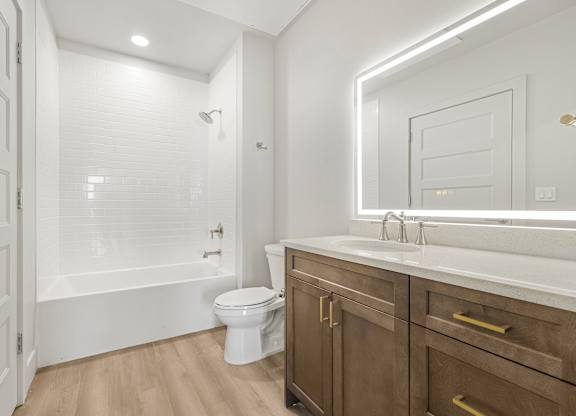 A white bathroom with a toilet, sink, and a walk-in shower.