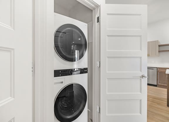 A white door opens to a modern kitchen.