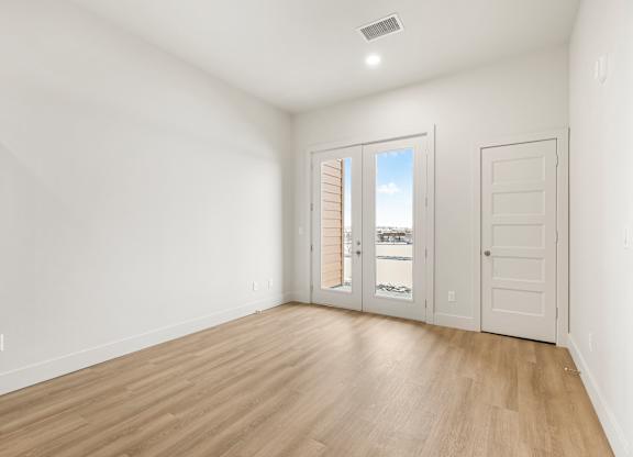 A room with a sliding glass door leading to a balcony.