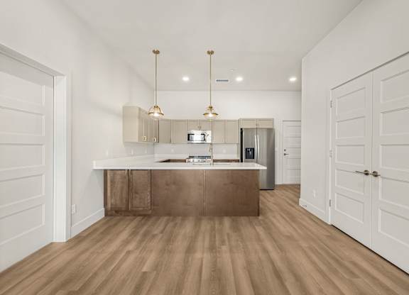 A kitchen with a wooden floor and white walls.