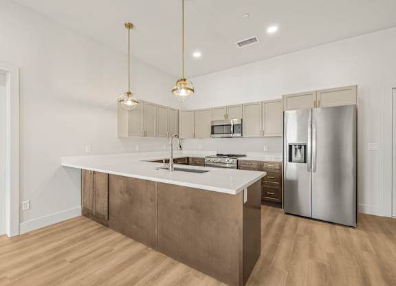 A modern kitchen with a large island and stainless steel appliances.