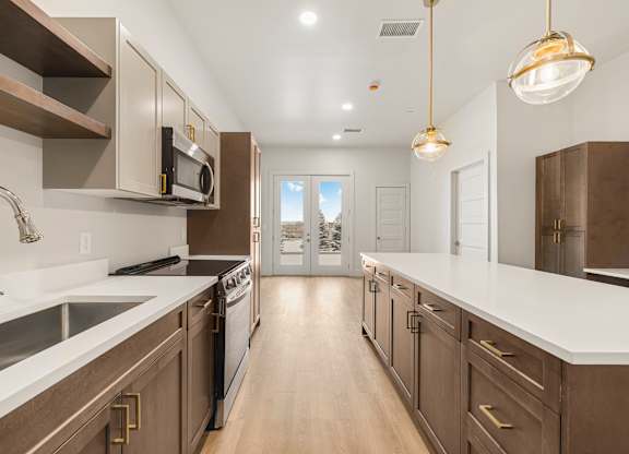 A modern kitchen with dark brown cabinets and white countertops.