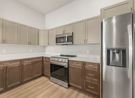 A kitchen with wooden cabinets and a stainless steel refrigerator.